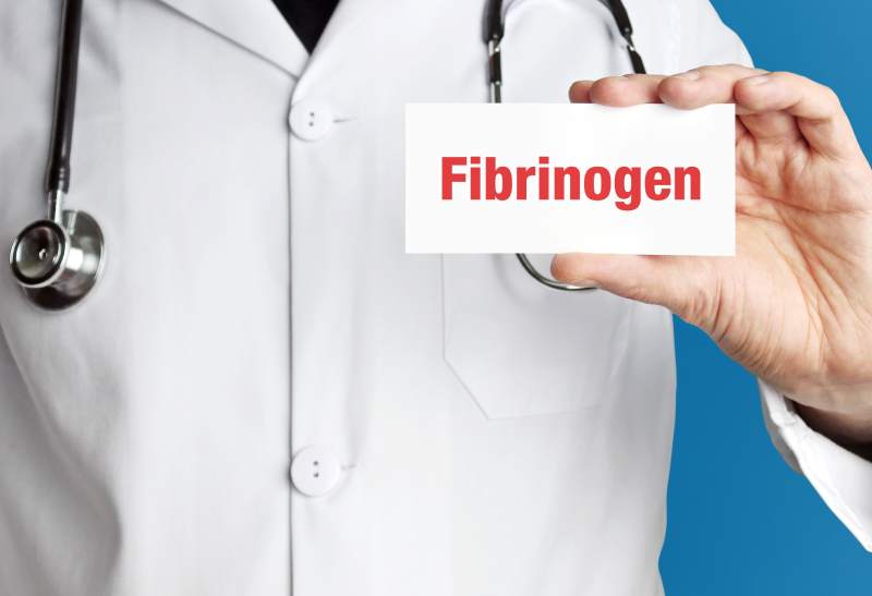 jak-obnizyc-fibrynogen-lekarz-trzyma-kartke-z-napisem-fibrynogen
